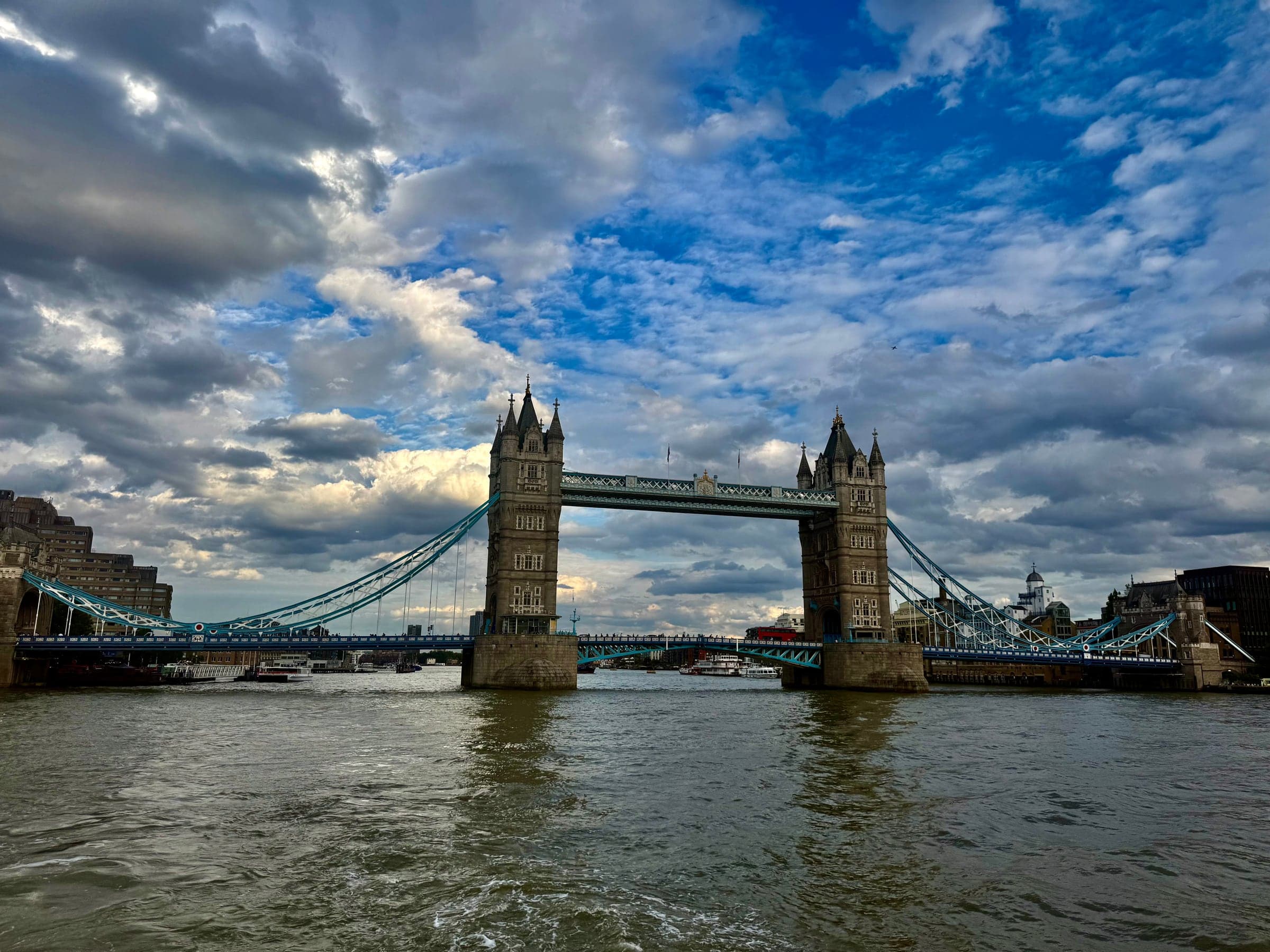 Tower Bridge seen from the river under broken cloud
