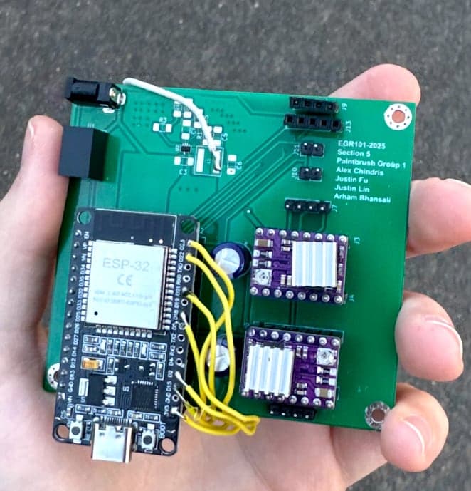 The assembled control PCB held in a hand, with an ESP32 board and two stepper driver modules plugged in
